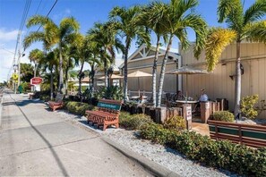 Relax in a tropical setting with outdoor seating areas and palm trees, surrounded by a simple, modern design.