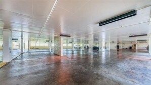 A spacious, empty parking garage with concrete floors and white pillars. - Tropical Oasis Directly on the Gulf!~  OS608 (Madeira Beach)
