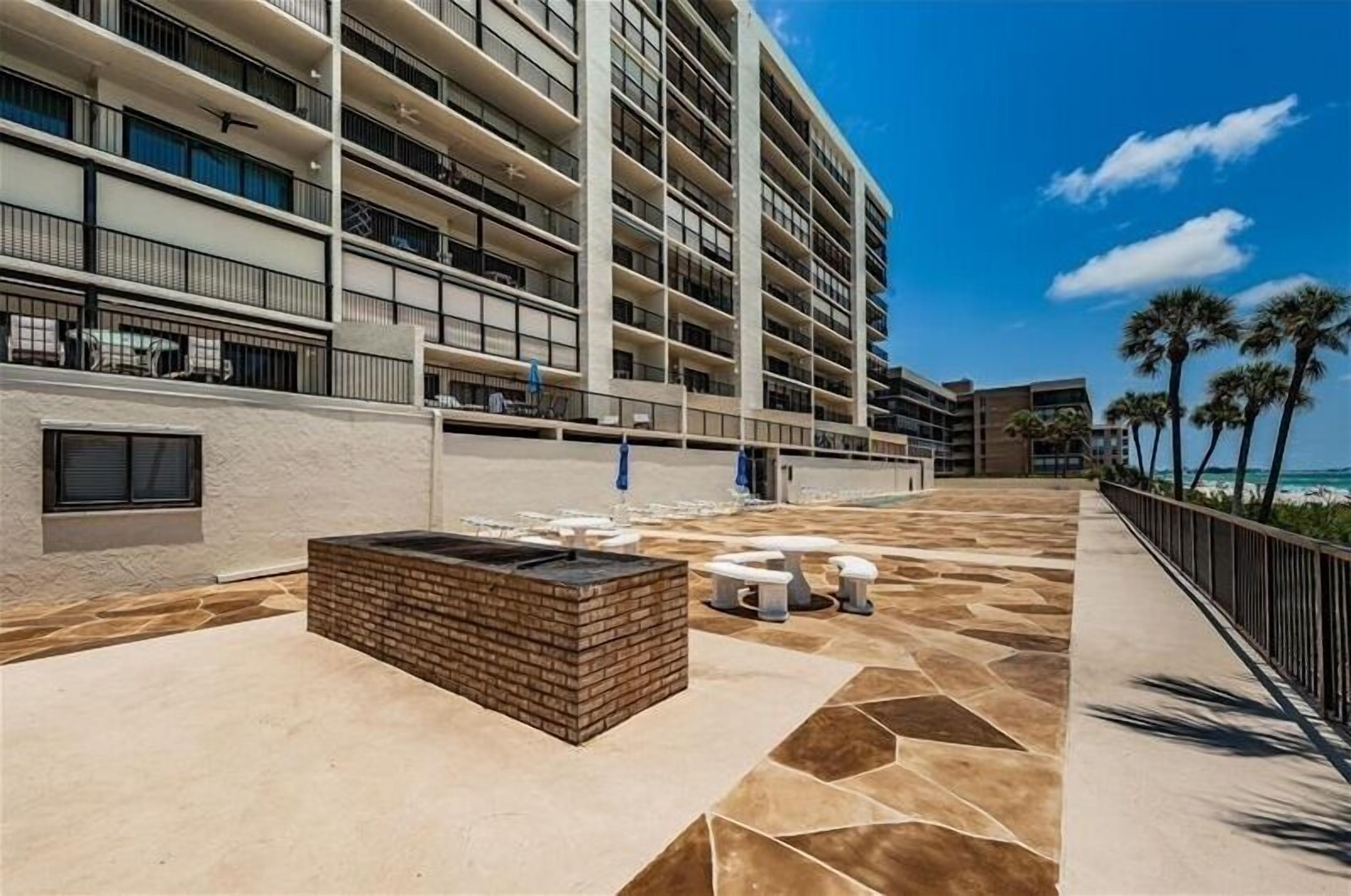 A multi-story hotel with outdoor seating and a pool area.