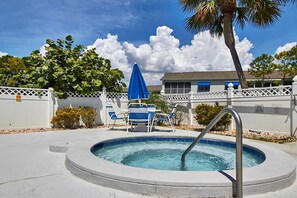 A swimming pool with a metal ladder, surrounded by a white fence, blue chairs, and a blue umbrella. - Amazing Location at the Ship Watch Yacht & Tennis Club 3 month rental~ Ship1815 (Largo)