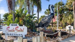 Naamplaatje voor het Seaside Seabird Sanctuary, met een groot beeld van een vogel.