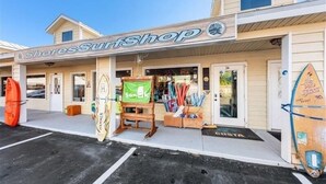 Een surfwinkel met een bord, surfplanken en een Costa do Mar bord.