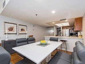 A modern kitchen with white cabinets, a refrigerator, and a microwave.