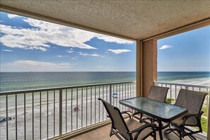 A balcony with a table and chairs overlooking a beach. - Pet Friendly, Direct Gulf Front Condo with Million Dollar Panoramic Views! ~ TP404 (Indian Shores)