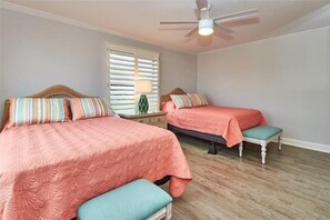 A bedroom with two beds, a ceiling fan, and a window with blinds. - Pet Friendly, Direct Gulf Front Condo with Million Dollar Panoramic Views! ~ TP404 (Indian Shores)