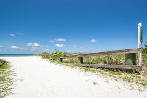 A sandy beach path with a wooden fence and a tall white post. - Pet Friendly, Direct Gulf Front Condo with Million Dollar Panoramic Views! ~ TP404 (Indian Shores)