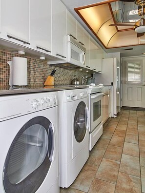 A laundry room with a washing machine, dryer, and microwave.