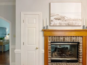A room with a fireplace, a door, and a framed picture on the wall.