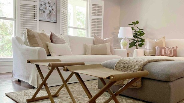 Ein Wohnzimmer mit einer Couch, einem Holztisch und einem gemusterten Teppich.