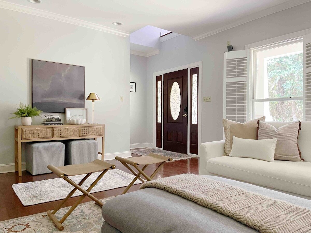 Una sala de estar con un sofá, una mesa de centro, un televisor y una puerta con ventanal.