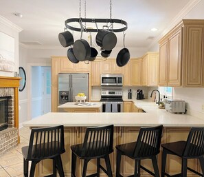 A modern kitchen with a central island, stainless steel appliances, and wooden cabinetry.