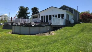 A two-story house with a covered porch and a swimming pool.