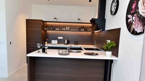 A compact kitchen with a built-in sink, a coffee maker, and a small countertop area.