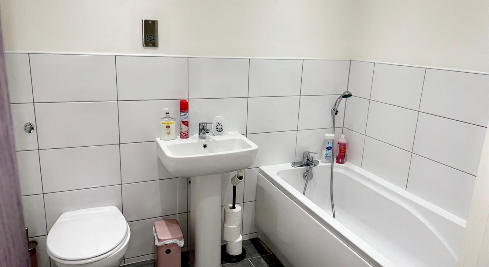 A bathroom with a toilet, sink, and bathtub.
