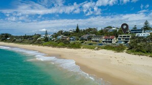 A coastal beach with houses and a clear sky.