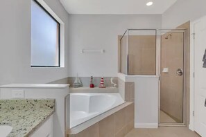 Een bad/douchecombinatie, handdoeken, toiletpapier