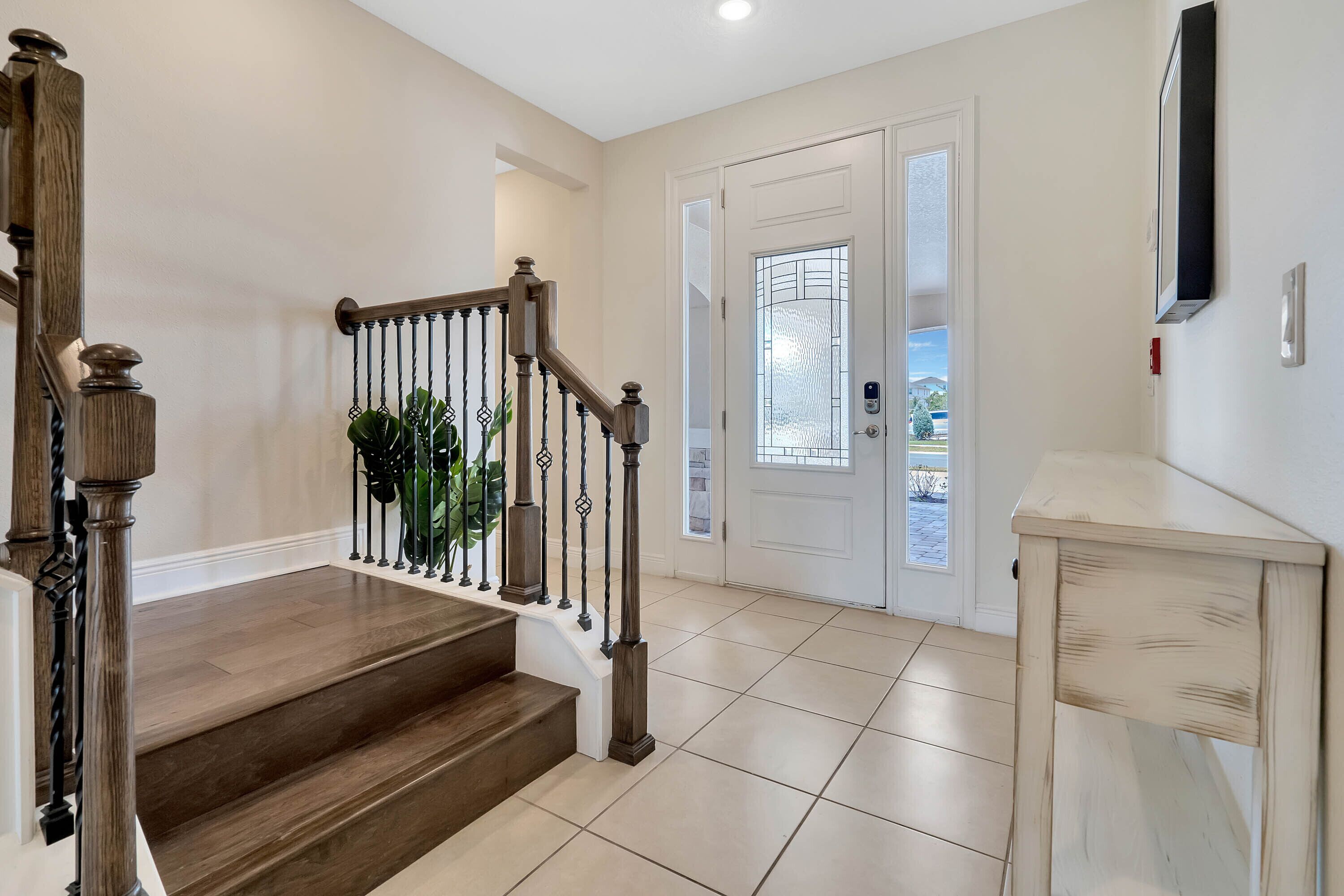 A staircase with wooden steps and a metal railing, leading to a door with a frosted glass panel.