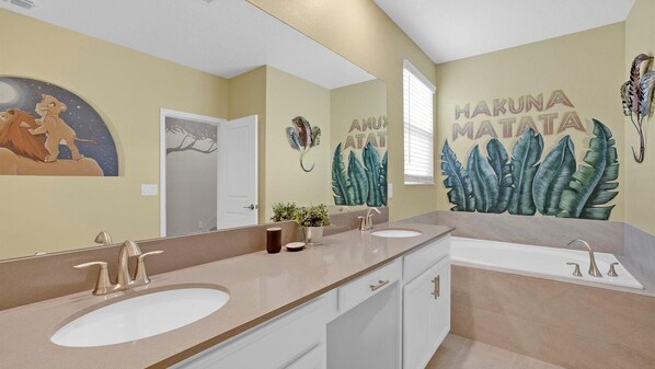 A bathroom with two sinks, a mirror, and a wall mural.