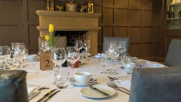 A dining table set for a meal with wine glasses, plates, and cutlery.