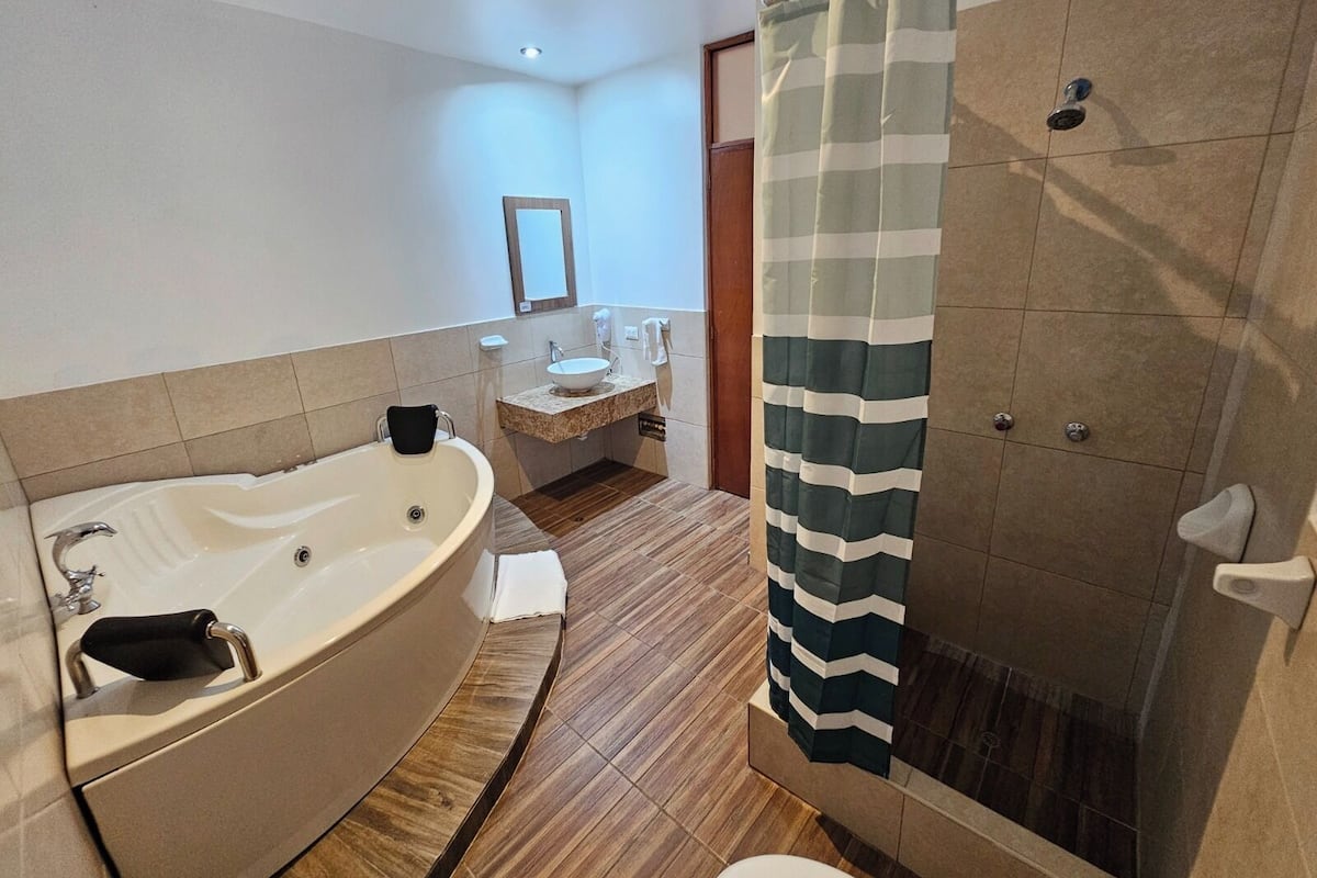 Un baño moderno con una bañera independiente, zona de ducha y tocador con lavamanos y espejo.