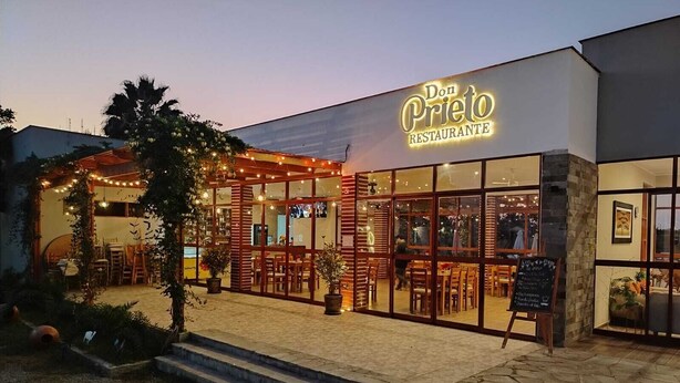 Un restaurante llamado Don Prieto Restaurante con terraza y guirnaldas de luces.