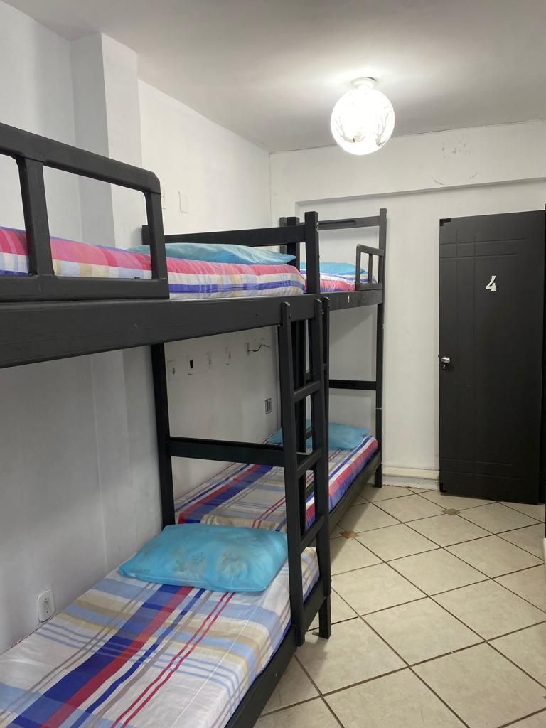 A bunk bed room with a door and a light fixture.