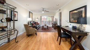 A spacious living room with a fireplace, a dining area with a dark wood table, and a kitchen visible through a sliding door. - CASA DE LA VIDA - Anasazi Village - Golf View (Phoenix)