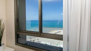 Ein Fenster mit Blick auf Strand und Meer.
