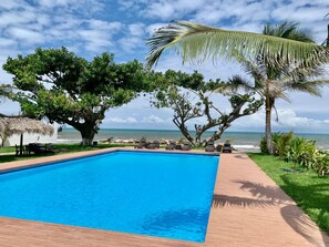 A rectangular swimming pool with a clear blue water surface, surrounded by a wooden deck.