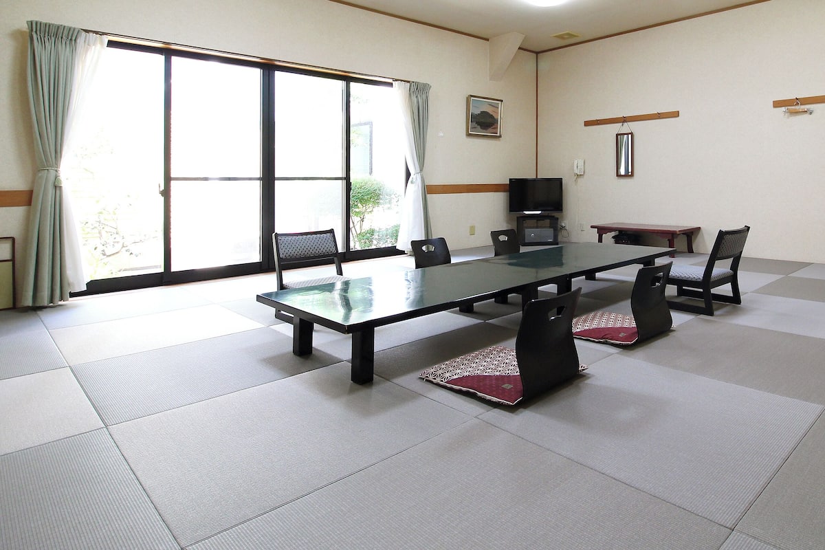 A conference room with a glass table, chairs, a television, and sliding glass doors.