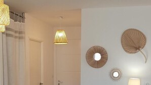 Una sala de estar con sofá, una mesa de centro con lámpara y una pared decorada con adornos.
