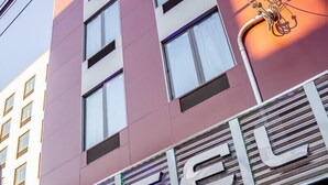 Un hotel con fachada moderna, amplias ventanas y un letrero destacado.