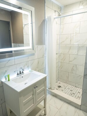 Deluxe King Smoking | Bathroom | Shower, hair dryer, towels, soap