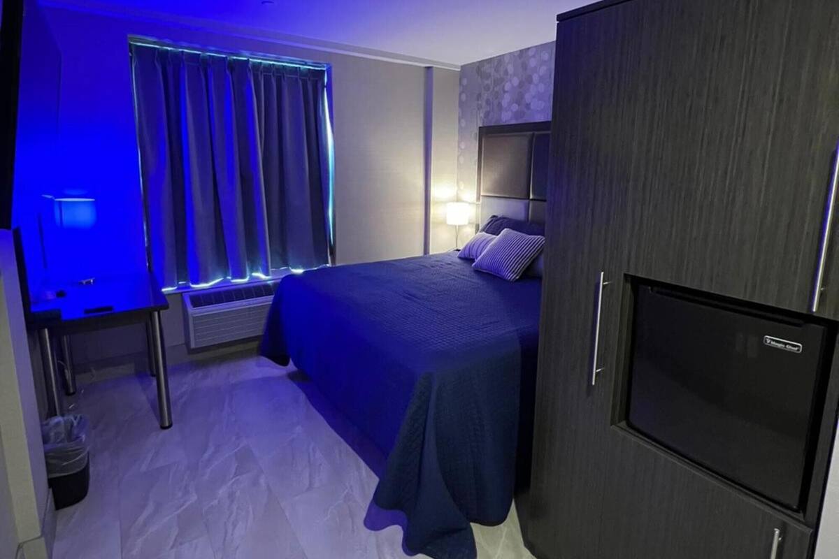 A hotel room with a bed, a TV, a desk, and a wardrobe.