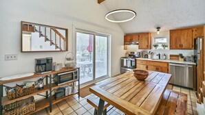 Una cocina moderna con armarios de madera, una gran mesa de madera y un horno empotrado.