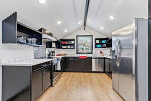 A modern kitchen with black cabinets, stainless steel appliances, and a wooden floor. - Perfectly located 3 bedroom - 2 bath apartment (Rapid City)