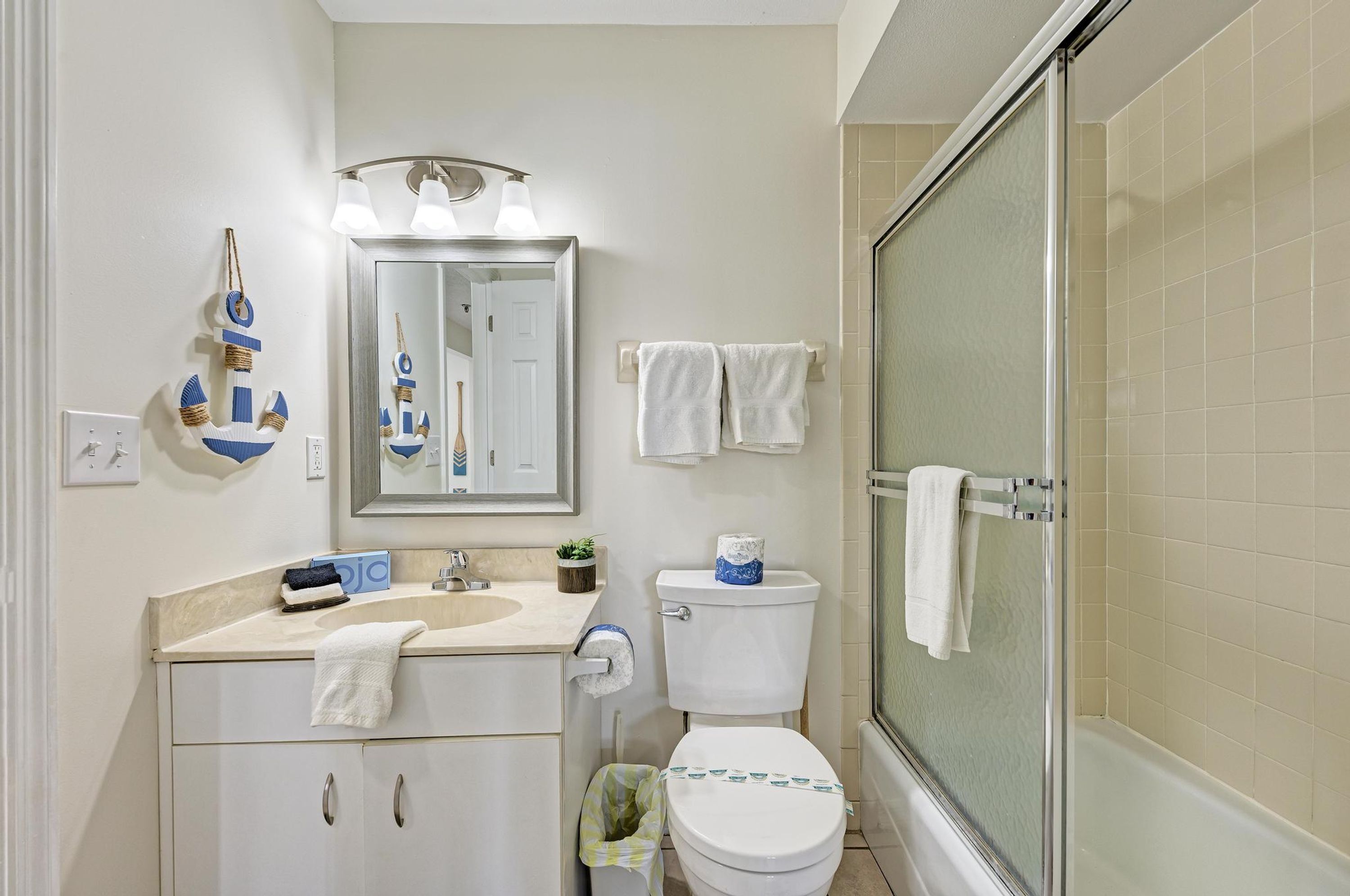 Un baño con inodoro, lavabo, espejo y ducha.