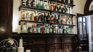 Zona de bar con estanterías llenas de botellas de licores y vasos.