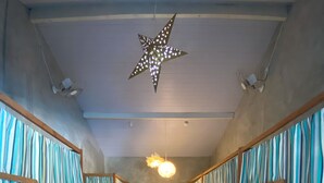 Un pasillo con literas, un armario y una lámpara en forma de estrella.