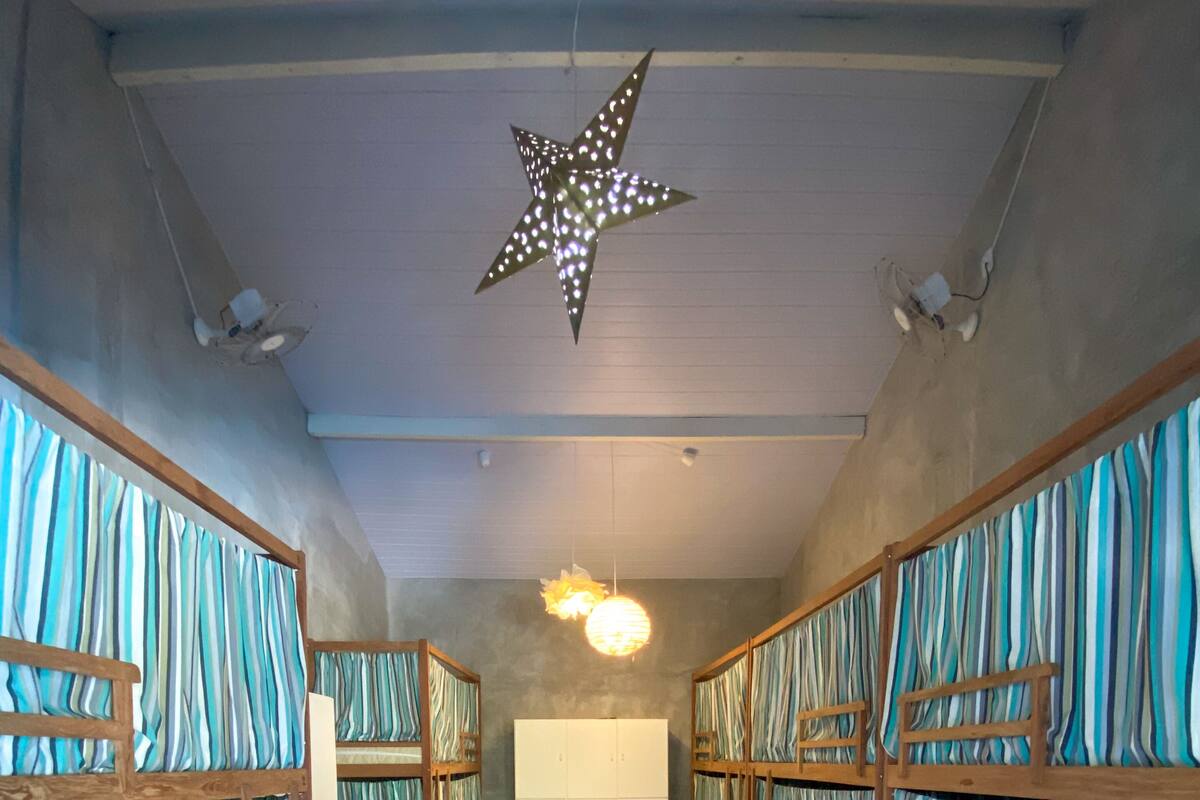 A hallway with bunk beds, a wardrobe, and a star-shaped light fixture.