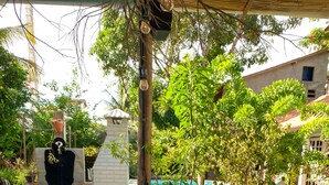 Un bufé de desayuno con diferentes alimentos y bebidas, una piscina al fondo y un entorno tropical.
