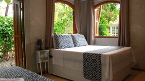Un dormitorio con una cama, una mesita de noche y una ventana con cortinas.