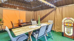 A tented area with a long table, chairs, and a jukebox. - Grill, Fire Pit: Pet-Friendly Lakeside Cottage! (Lakeside)