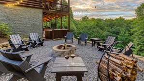 An outdoor seating area with Adirondack chairs, a fire pit, and a table with wine glasses. - Mountain View Cabin - Hot Tub - Fire Pit - Pool Table - Game Room (Mineral Bluff)
