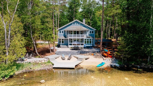 Ein Haus mit Terrasse, kleinem Pool und einem Kajak.
