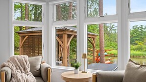 Ein gemütliches Zimmer mit Blick auf eine hölzerne Spielanlage und einen Teich.
