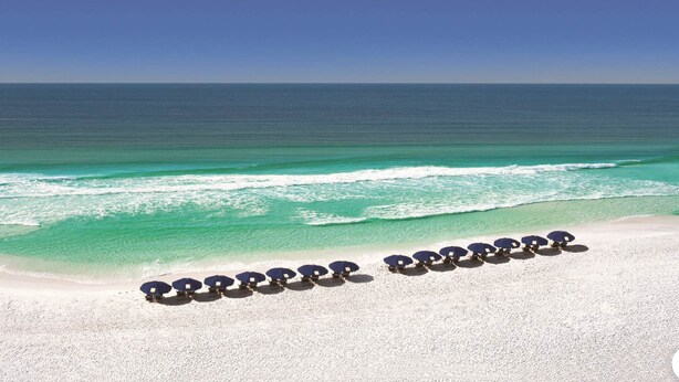 Una playa con arena blanca y agua turquesa cristalina.