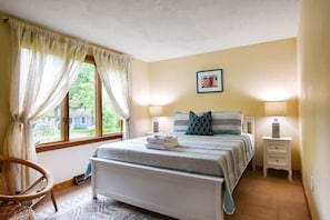 A bedroom with a bed, two bedside tables, a chair, a window with curtains, and a wall-mounted picture. - Central AC 3 Min Walk to Pond! (Marstons Mills)