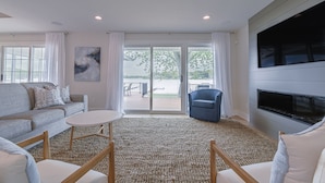 A modern living room with a sofa, chairs, a coffee table, and a fireplace.
