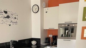 Een kleine keuken met een spoelbak, kookplaat en keukenkastjes.